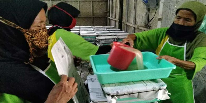 Karyawan sedang mengolah air kelapa hasil fermentasi untuk dijadikan nata de coco.