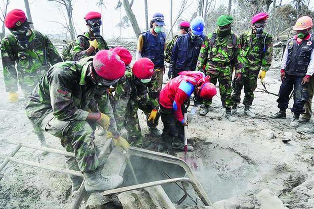 Tim Kopassus bersama relawan berusaha mengeluarkan jenazah yang berada di dalam mobil dan tertimbun lahar di Dusun Ngepringan, Wukirsa ri, Cangkringan, Sleman, DI Yogyakarta, Selasa (9/11). Pencarian korban masih terus dilakukan karena diperkirakan masih terdapat jenazah yang belum ditemukan.