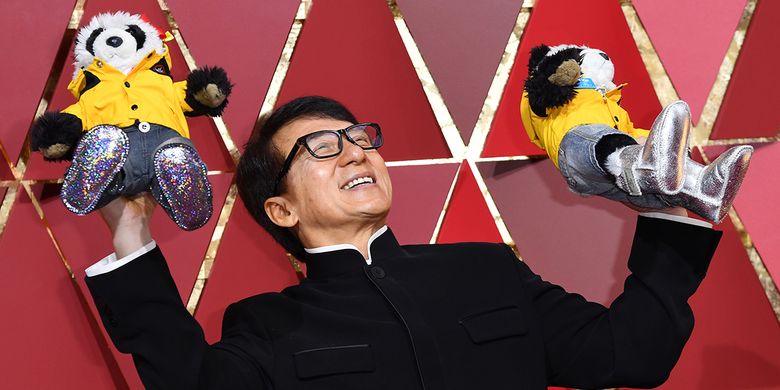 Aktor asal Hong Kong, Jackie Chan, berpose dengan memegang dua boneka panda ketika berjalan di karpet merah pada malam puncak Academy Awards 2017 di Hollywood, California, Minggu (26/2/2017).