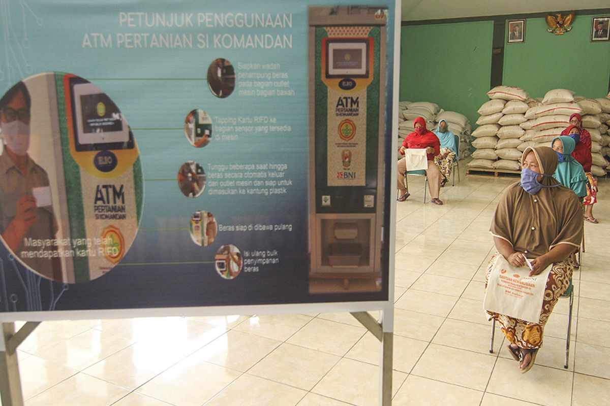 Sejumlah warga mengantre untuk mendapatkan beras gratis dengan ATM Pertanian Sikomandan di Kodim 0508/Depok, Jawa Barat, Minggu (26/4/2020). Kementerian Pertanian menyediakan ATM beras gratis di sejumlah Kodim di wilayah Jabodetabek berkapasitas 1,5 ton beras per harinya untuk 1.000 warga sebagai upaya membantu masyarakat yang terkena terdampak COVID-19.