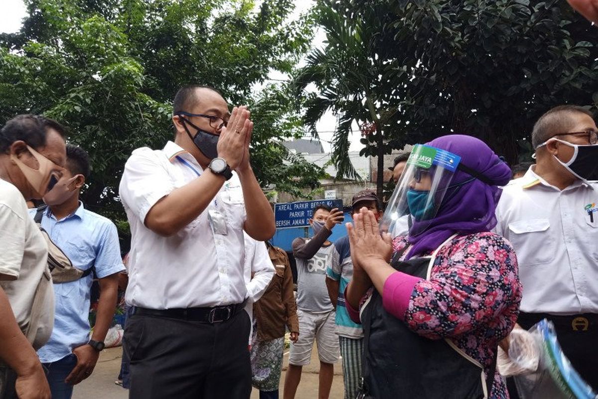 Direktur Utama Perumda Pasar Jaya Arief Nasrudin (kiri) berdialog dengan pedagang sayur di Pasar Perumnas Klender, Jakarta Timur, terkait sosialisasi perdana ganjil genap operasional kios, Senin (15/6/2020). 