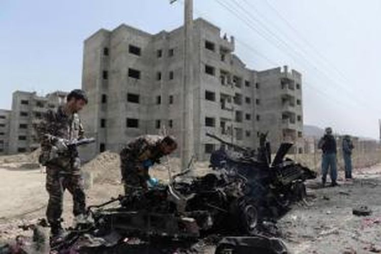 Tentara Afghanistan memeriksa lokasi serangan bom yang dilakukan oleh gerilyawan Taliban di Bandara Kabul, Afghanistan, 17 Juli 2014.