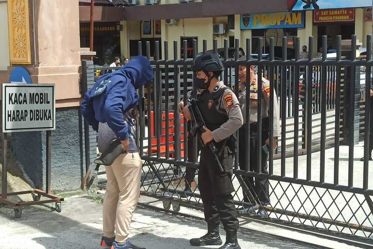 Petugas kepolisian memeriksa seorang tamu yang datang ke Polresta Pekanbaru dalam rangka memperketat keamanan usai kejadian ledakan bom bunuh diri Mapolsek Astanaanyar, Bandung, Jawa Barat, Rabu (7/12/2022) pagi.
