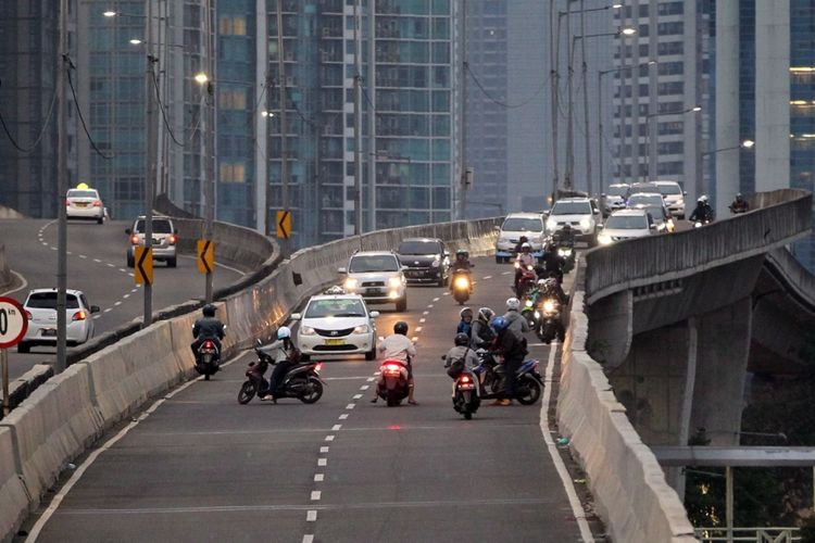 Pengendara sepeda motor nekat melawan arah saat berlangsung razia di jalan layang non tol (JLNT) Kampung Melayu-Tanah Abang, Jakarta, Selasa (25/7/2017). Pengendara motor masih nekat memasuki dan melintasi JLNT tersebut baik dari arah Tanah Abang maupun Kampung Melayu. KOMPAS IMAGES/KRISTIANTO PURNOMO