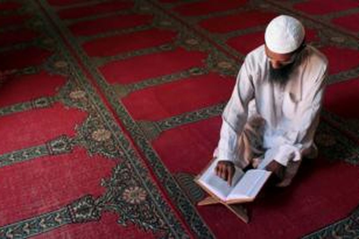 Seorang umat Muslim Banglades tengah membaca kitab suci Al Quran di sebuah masjid di saat bulan suci Ramadhan.