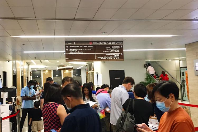 Di tengah wabah virus corona, pengunjung Rumah Sakit Mount Elizabeth, Orchard, Singapura terlihat mengantre panjang untuk pengisian data diri dan pemeriksaan suhu tubuh sebelum memasuki area rumah sakit, Februari 2020.  
