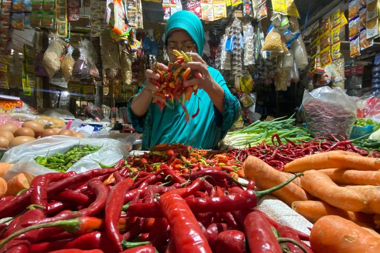HARGA NAIK—Salah satu pedagang di Pasar Caruban Baru, Mejayan, Kabupaten Madiun, Jawa Timur menunjukkan cabai yang mengalami kenaikan harga memasuki bulan Suro, Senin (30/6/2025).