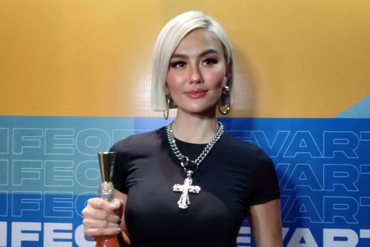 Penyanyi Agnez Mo memegang botol wine yang diproduksinya saat jumpa pers peresmian bisnis restorannya, Senovarti di kawasan Senopati, Jakarta Selatan, Minggu (2/10/2022).