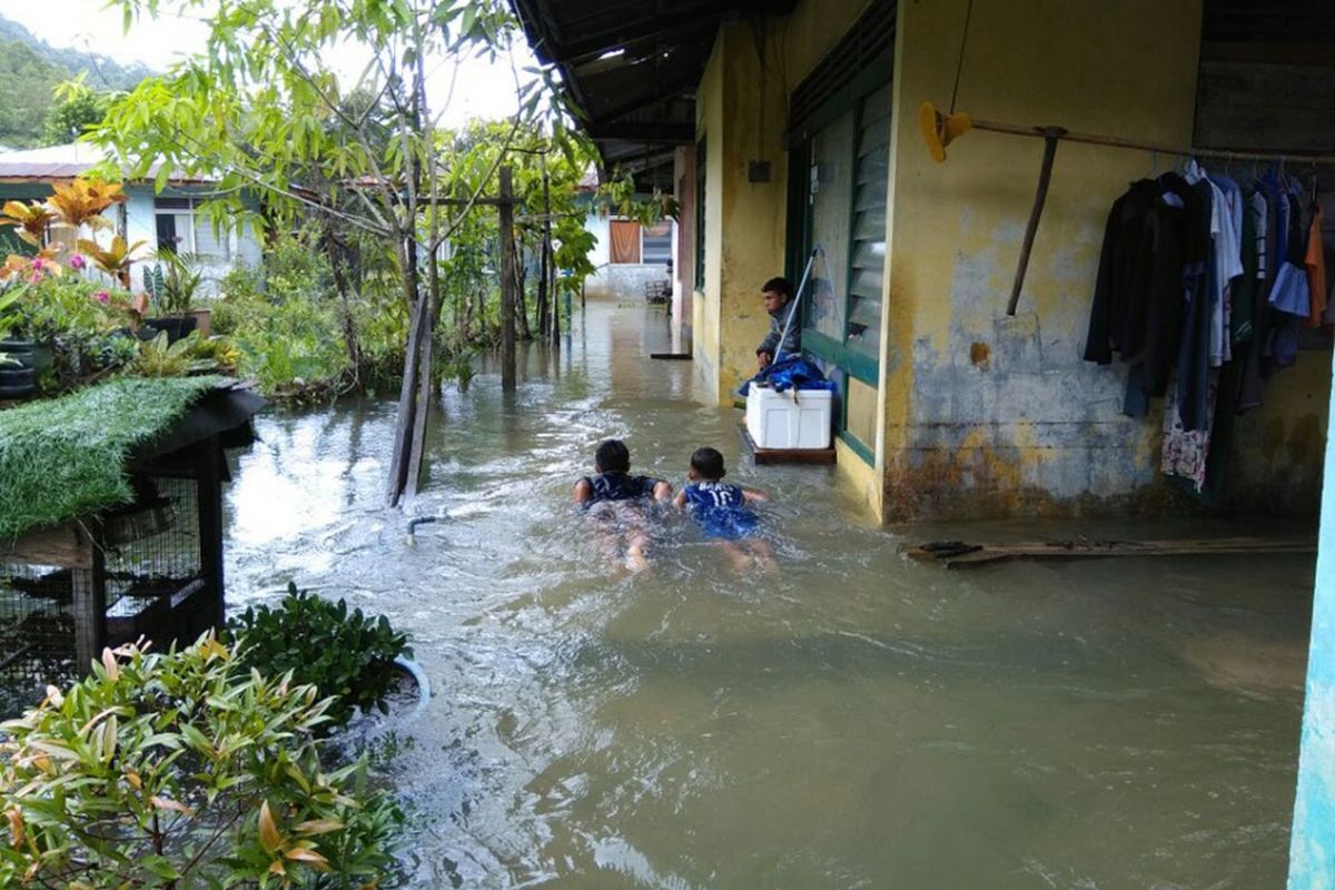 Dua orang anak di Tambelan terlihat asik berenang di halaman rumahnya yang kebanjiran, Minggu (14/1/2018). Kawasan Tambelan dilanda Banjir dan tanah Longsor pada akhir pekan ini.