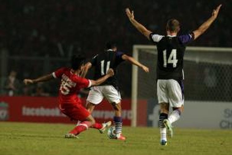 Pemain Indonesia Ahmad Jufrianto (kiri) bergelut dengan pemain Liverpool Oussama Assaidi (tengah) dalam pertandingan persahabatan di Stadion Utama Gelora Bung Karno, Senayan, Jakarta, Sabtu (20/7/2013) malam. Liverpool menang 2-0.