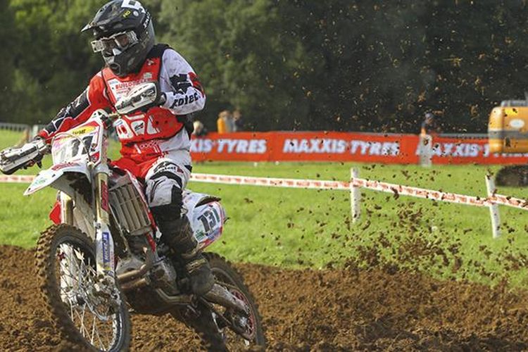 Pebalap motocross memacu motornya dalam balapan.