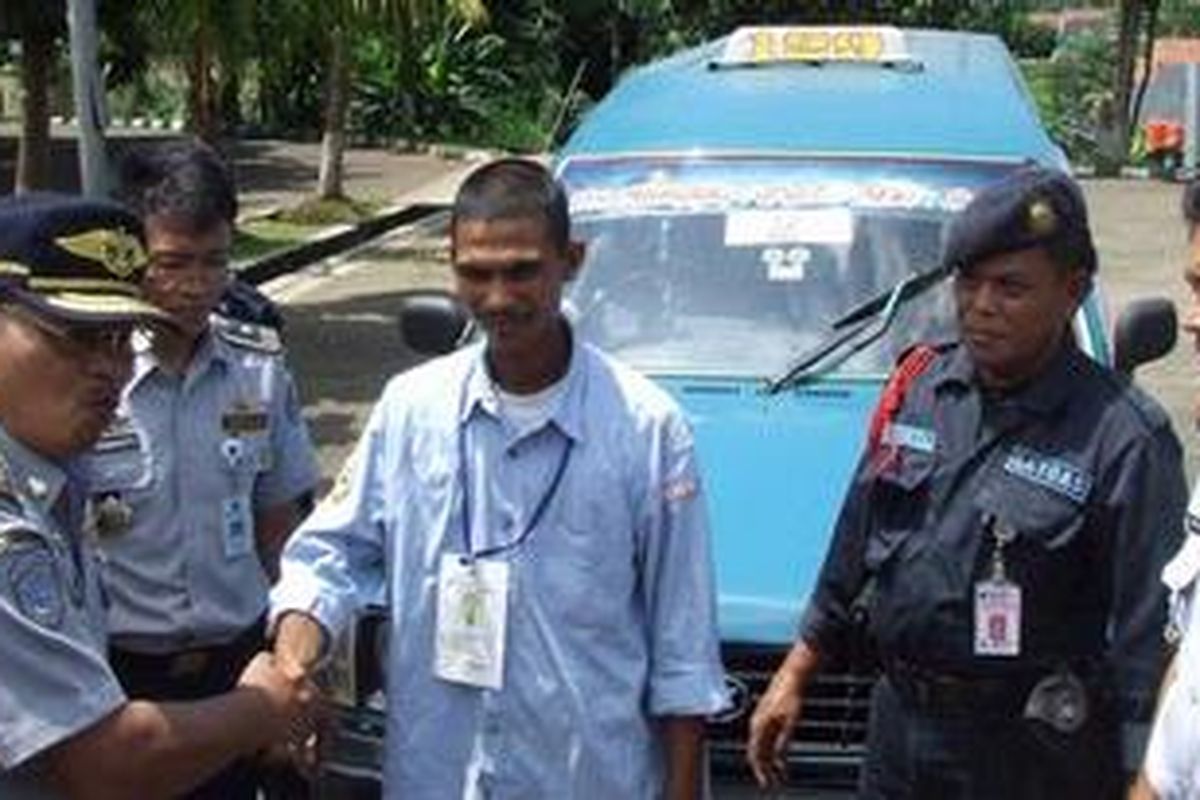 Kepala Dinas Perhubungan Kota Depok Dindin Djaenudin (kiri) secara simbolis membantu sopir mengenakan seragam, Jumat (30/12/2011). Mulai hari ini Pemkot Depok mengenalkan seragam bagi sopir angkot untuk mengurangi gangguan keamanan penumpang.