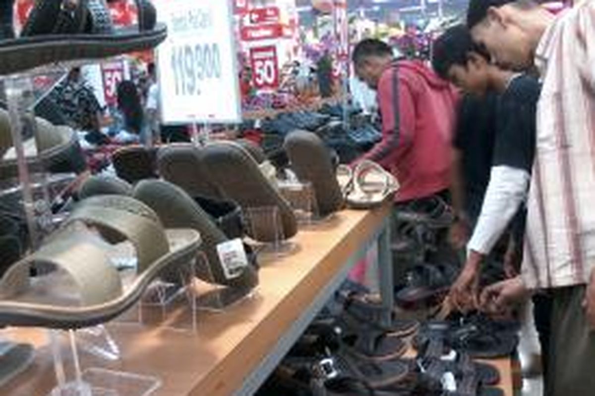 Para pengunjung sedang melihat berbagai produk sandal yang mendapat potongan harga di Pasar Modern Kebayoran Lama, Jakarta Selatan.
