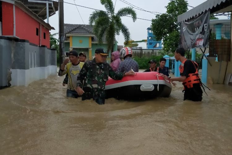 Dandim 0604 Karawang Letkol Infantri Medi Haryo Wibowo ikut membantu mengevakuasi warga yang terdampak banjir di Desa Tegalwaru, Cilamaya Wetan, Kabupaten Karawang, Kamis (6/1/2020).