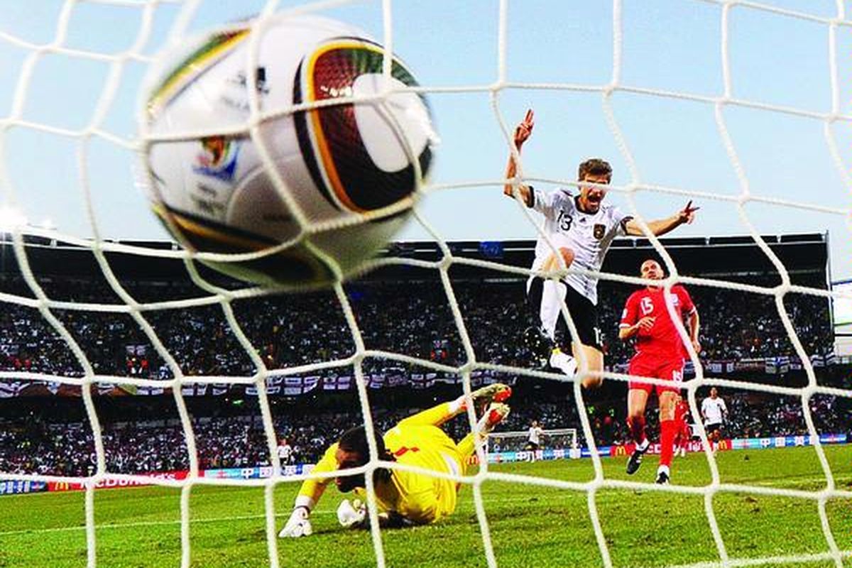Gelandang Jerman, Thomas Mueller (tengah), melompat gembira setelah mencetak gol yang keempat bagi Jerman ke gawang Inggris yang dijaga David James (bawah) pada laga perdelapan final Piala Dunia 2010 di Free State, Bloemfontein, Afrika Selatan, Minggu (27/6). Jerman menang 4-1.