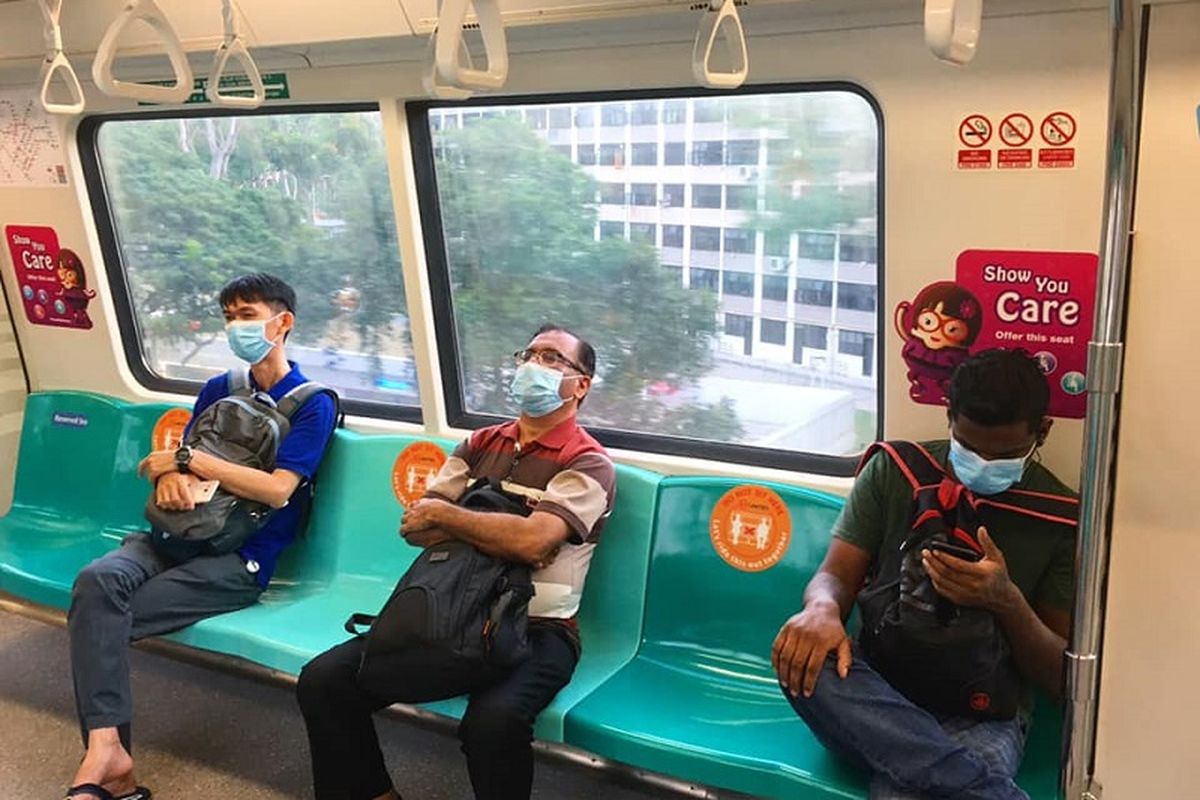 Penumpang MRT Singapura jalur Timur-Barat atau warna hijau yang sedang melewati daerah Queenstown duduk dengan masker terpasang di mulut masing-masing, Minggu sore (19/04/2020). Menghadapi pandemi Covid-19, pemerintah Singapura mewajibkan seluruh warganya untuk memakai masker ketika keluar meninggalkan rumah.