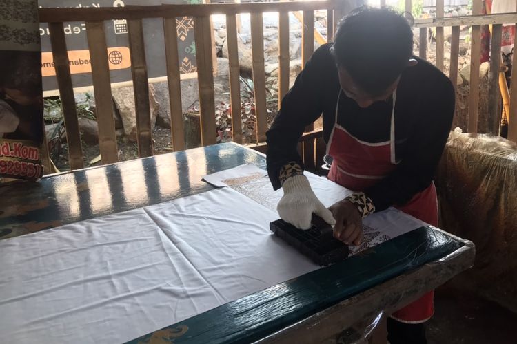 Pemilik usaha batik khas Minang bermerek Salingka Tabek, Yusrizal (29) saat ditemui di rumahnya di Sawah Parik, Desa Bawah Duku, Kecamatan Kotobaru, Solok, Sumatera Barat pada Rabu (18/5/2022). Ia sedang mempraktekkan proses pembuatan batik cap.