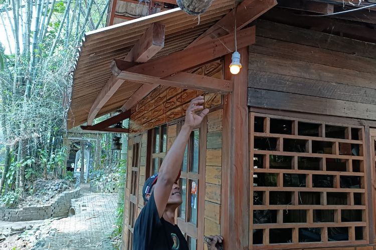 Sugeng Widodo saat menunjukan lampu yang dihasilkan dari pembangkit listrik alternatif sumber daya air dari sungai Anak Molek