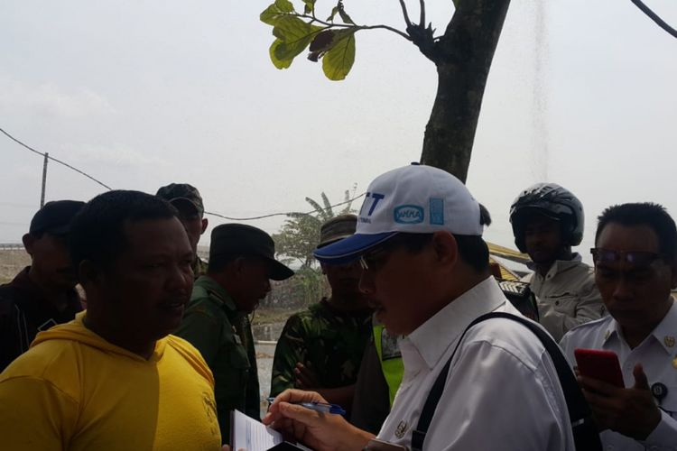 Mujiyanto (kiri) nampak diwawancarai petugas dari Dinas Energi dan Sumber Daya Mineral (ESDM) Jawa Timur di lokasi semburan air disertai gas di Desa Sidolaju, Kecamatan Widodaren, Kabupaten Ngawi, Jawa Timur, Rabu (8/8/2018)