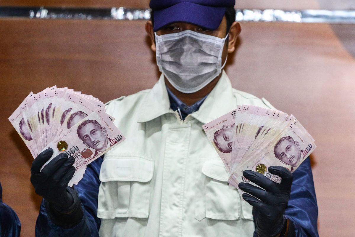 Petugas menunjukkan barang bukti mata sang dolar Singapura saat konferensi pers terkait Operasi Tangkap Tangan (OTT) Direktur Keuangan PT Angkasa Pura II di Gedung KPK, Jakarta, Kamis (1/8/2019). KPK menetapkan dua orang tersangka yakni Direktur Keuangan PT Angkasa Pura II Andra Y. Agussalam sebagai penerima suap dan Staf PT INTI Taswin Nur sebagai pemberi suap serta mengamankan barang bukti sebesar 96.700 dolar Singapura terkait kasus suap pengadaan pekerjaan Baggage Handling System (BHS) di PT Angkasa Pura Properti.