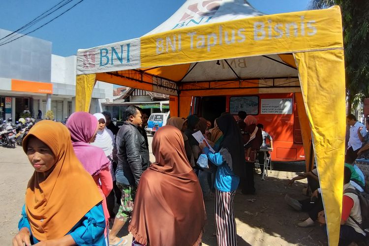 CAIRKAN DANA--Warga Gemarang, Kecamatan Gemarang, Kabupaten Madiun mengantri mencairkan dana PKH tahap kedua di Kantor Cabang Pembantu Bank BNI Caruban. Untuk mencairkan dana tersebut, warga dikenakan biaya transport hingga Rp 30.000