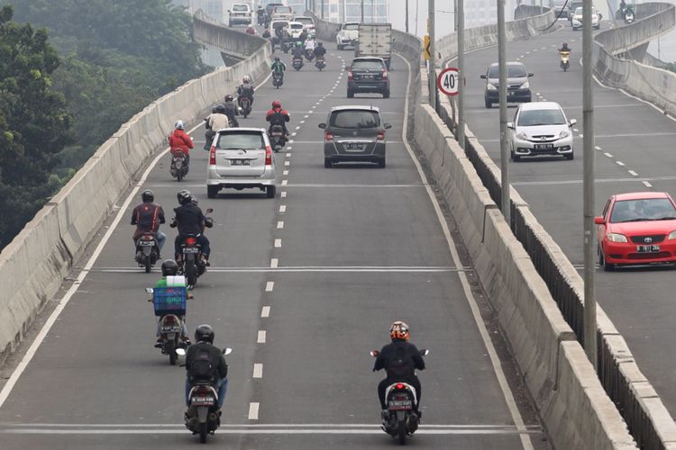 Sejumlah sepeda motor nekat menerobos ke jalan layang non tol (JLNT) Kampung Melayu-Tanah Abang, Jakarta, Senin (24/7/2017). Dinas Perhubungan DKI Jakarta bekerja sama dengan Korps Lalu Lintas (Korlantas) Polri telah melakukan razia untuk menertibkan pengendara sepeda motor yang melintas di JLNT tersebut. KOMPAS IMAGES/KRISTIANTO PURNOMO