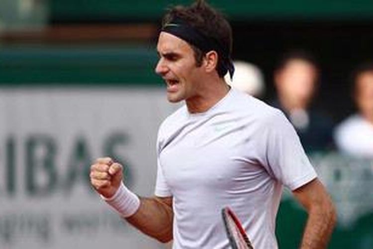 Petenis Swiss, Roger Federer, berteriak dan mengepalkan tangan setelah meraih poin, saat menghadapi Gilles Simon di babak keempat French Open, Minggu (2/6/2013).