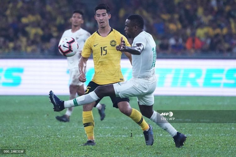 Brendan Gan (kiri-kuning) berebut bola dengan Greg Nwokolo (kanan-putih) pada laga Malaysia Vs Indonesia dalam lanjutan Kualifikasi Piala Dunia 2022 Grup G di Stadion Nasional Bukit Jalil, Selasa 19 November 2019.