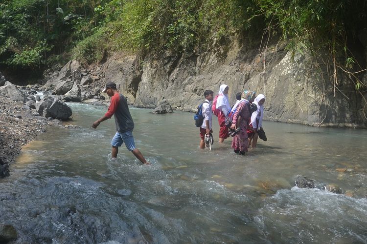 Warga menyeberangi Sungai Mondo yang memisahkan Dusun Punggung, Desa Duren dan Desa Lebakwangi, Kecamatan Pagedongan, Banjarnegara, Jawa Tengah, Senin (18/7/2022).