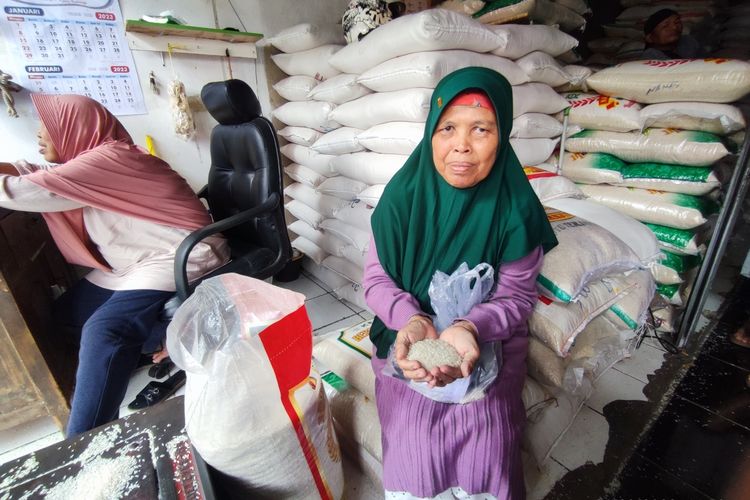 Juju Jubaedah, pembeli beras asal Leuwimunding Majalengka membeli beras di Sentra Beras Pasar Pagi Kota Cirebon menunjukan harga beras yang sedang naik, pada Senin (6/2/2023). Juju mengaku tidak mendapatkan beras dari pabrik pelanggannya karena ketiadaan beras untuk digiling.