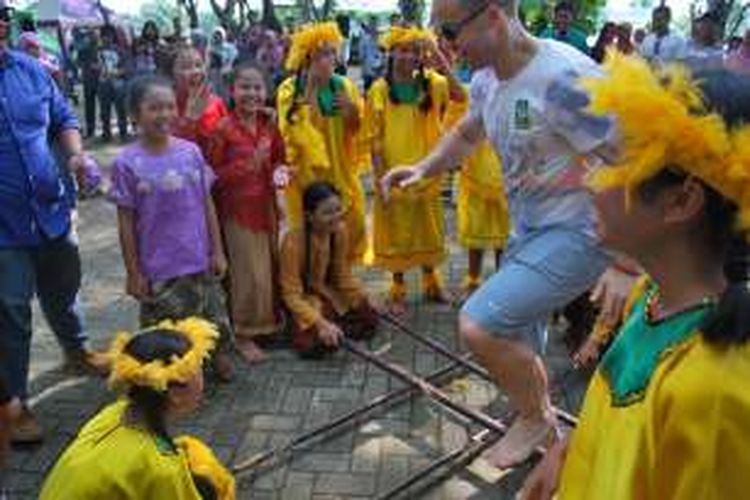 Anak-anak sedang bermain permainan tradisional bersama wisatawan asing yang datang ke Taman Buah Mekarsari.