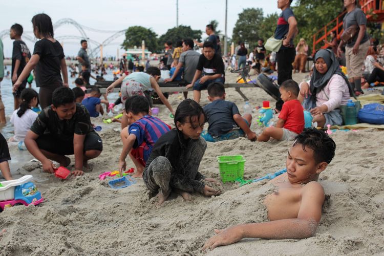 Warga memadati Pantai Lagoon Taman Impian Jaya Ancol, Jakarta pada hari kedua libur Lebaran, Minggu (23/4/2023). Taman Impian Jaya Ancol masih menjadi destinasi favorit untuk menghabiskan waktu libur Lebaran.