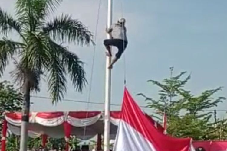 Tangkapan layar seorang petani memanjat tiang bendera saat upacara 17 Agustus 2022 di Kecamatan Jayakerta, Kabupaten Karawang, Jawa Barat.