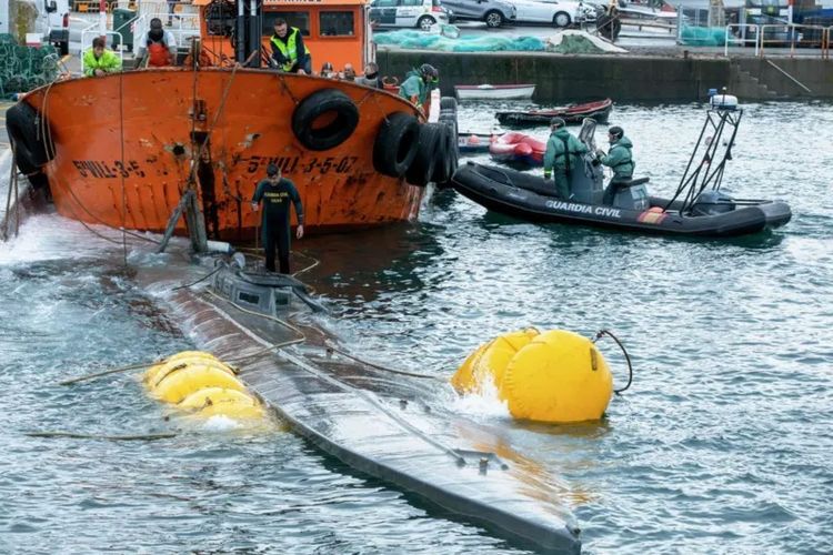 Tim penyelam Angkatan Laut Spanyol berdiri di atas haluan kapal selam mini yang digunakan untuk menyelundupkan narkoba di perairan Kota Aldan, Spanyol, 26 November 2019. 
