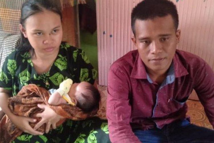 Jatar Simanjuntak (26) dan istrinya Suci Mayang Sari (20) menggendong bayi semata wayang mereka yang berusia beberapa minggu dengan kondisi lahir tanpa anus (Tribun Medan/ Alija Magribi)
