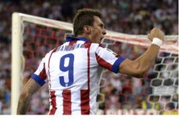 Penyerang Atletico Madrid, Mario Mandzukic, merayakan gol yang dicetaknya ke gawang Real Madrid pada leg kedua Piala Super Spanyol di Vicente Calderon Stadium, Madrid, Jumat (22/8/2014).