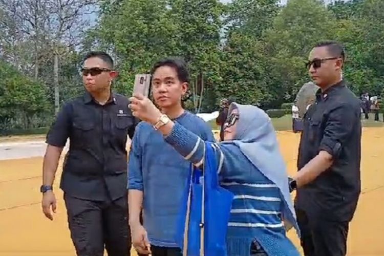 Putra sulung Presiden Joko Widodo, Gibran Rakabuming Raka saat meladeni wisatawan untuk berfoto di Candi Borobudur, Sabtu (25/5/2024).