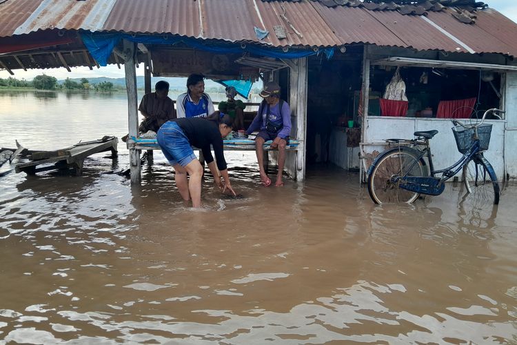 Foto: Para petani di Desa Kendit Kecamatan Kendit Kabupaten Situbondo menunggu air surut paska banjir di warung untuk bisa beraktivitas kembali pada Rabu (1/3/2023).