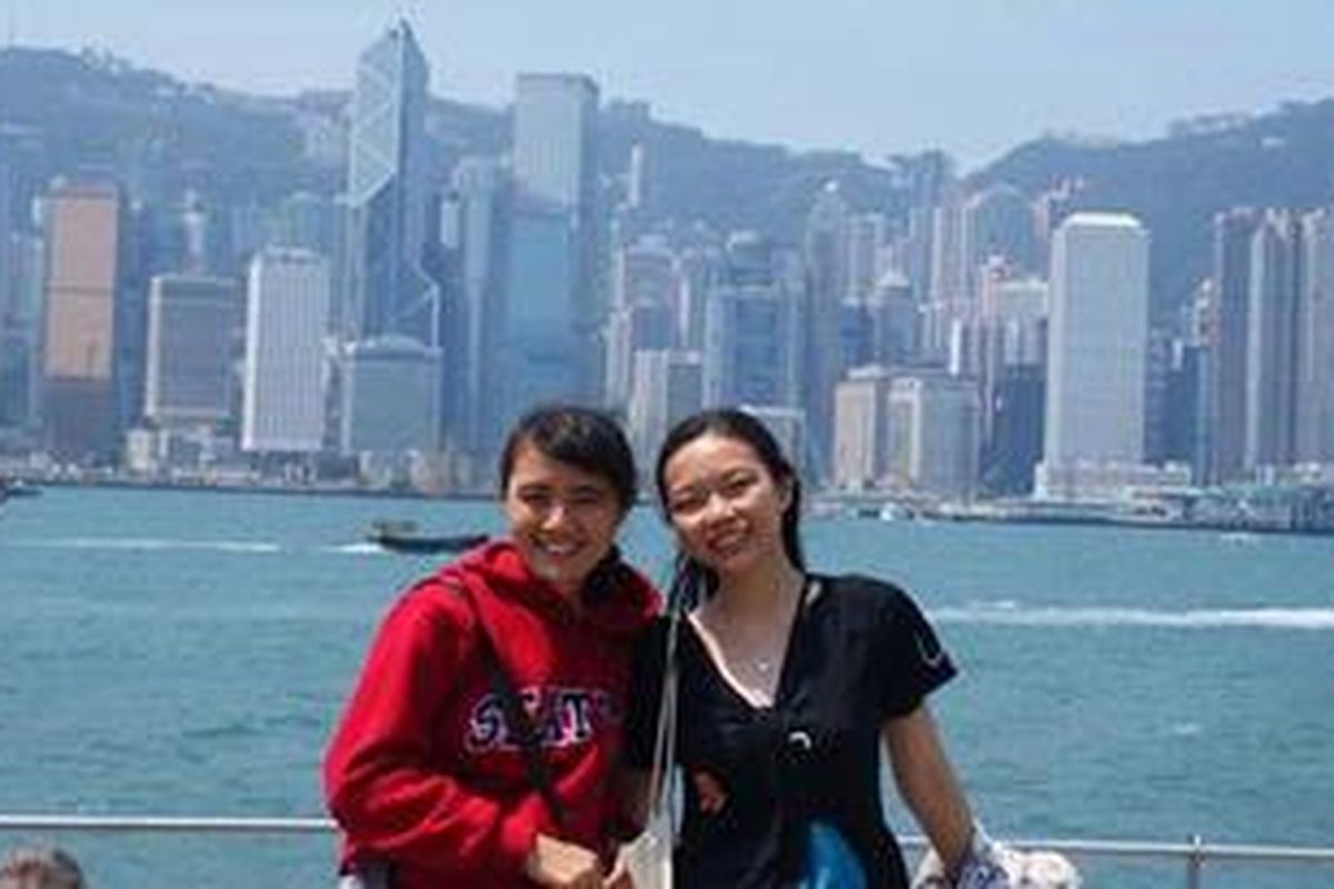 Berpose dengan latar belakang Hong Kong.