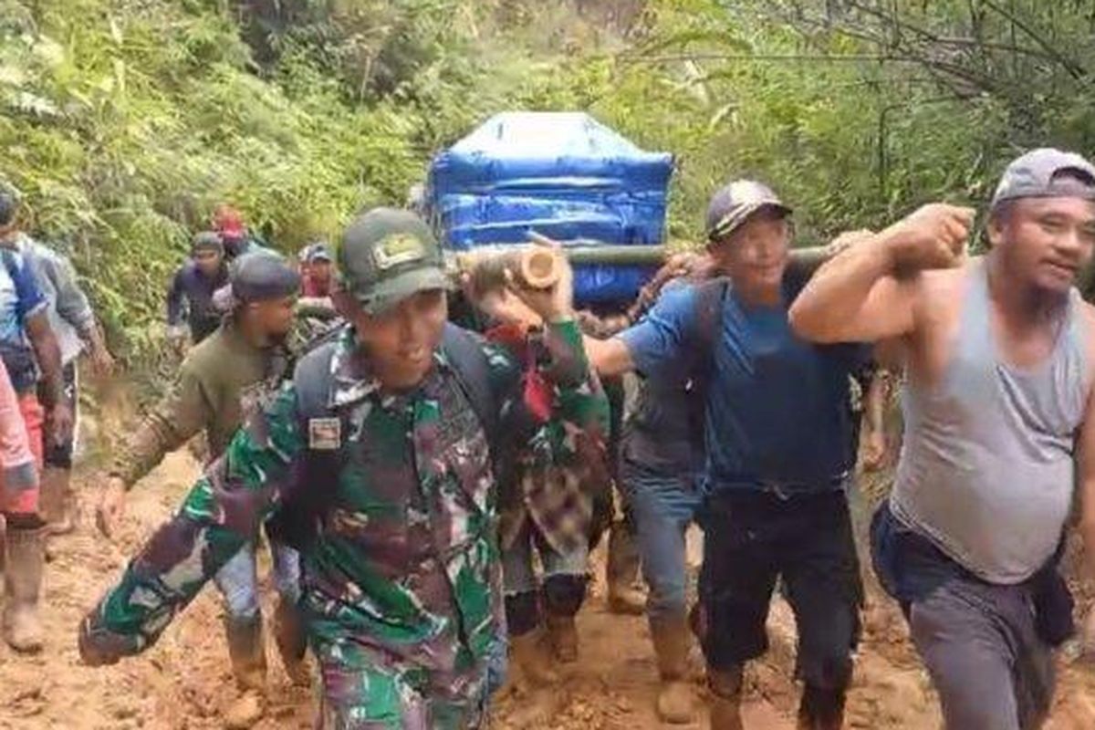 JALAN RUSAK - Warga dan Babinsa Seko membawa peti berisi jenazah purnabakti guru menuju rumah duka di Seko, Senin (19/5/2025). Warga harus berjalan kaki sekira 30 kilometer karena kondisi jalan yang rusak.