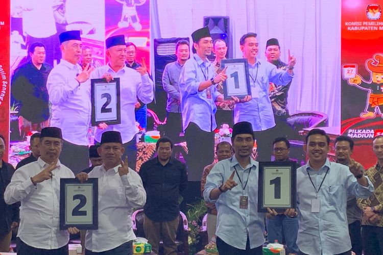 Pasangan calon bupati dan wakil bupati, Ahmad Dawami Ragil Saputro-Sandhika Feryantiko (Madiun Menyala) menunjukkan hasil undian nomor 1 dan Hari Wuryanto-Purnomo Hadi (Harmonis) memperoleh nomor urut 2 pada pengundian nomor urut pemilihan kepala daerah dan wakil kepala daerah (pilkada) 2024 di Kantor KPU Kabupaten  Madiun, Senin (23/9/2024) malam.