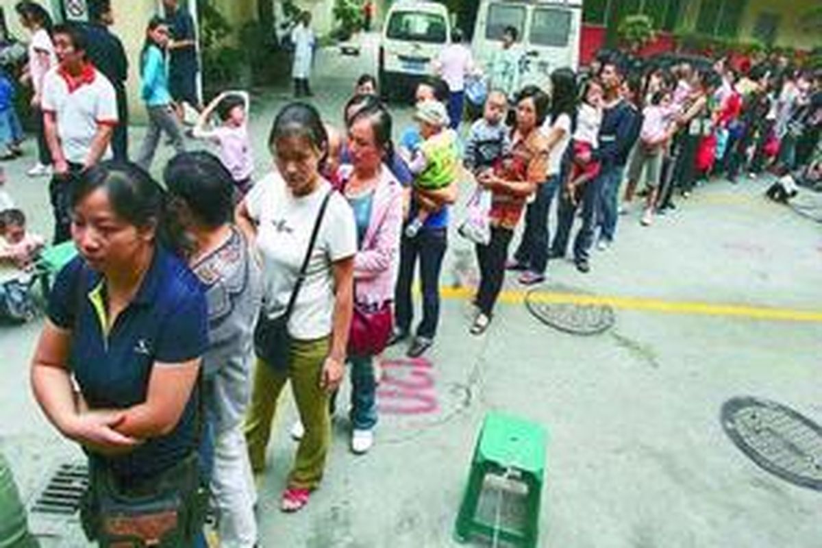 Para orangtua dan anak-anak menunggu giliran untuk pemeriksaan kesehatan di rumah sakit anak di Chengdu, ibu kota Provinsi Sichuan, China, Jumat (19/9). Ribuan orangtua yang panik mendatangi rumah sakit karena khawatir anak-anak mereka keracunan susu buatan lokal yang berbahaya.