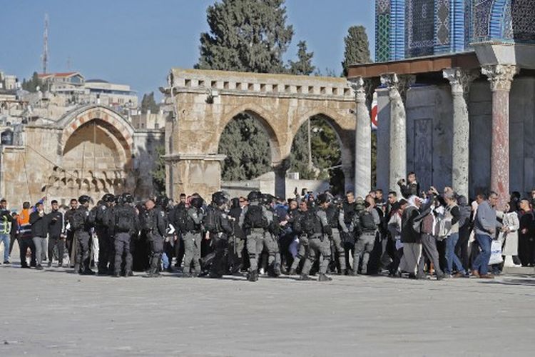 Warga Palestina dihadang oleh polisi Israel selama bentrokan terjadii di kompleks Masjid Al-Aqsa Yerusalem, pada Jumat (15/4/2022).  Saksi mata mengatakan bahwa pengunjuk rasa Palestina melemparkan batu ke pasukan keamanan Israel, yang menembakkan peluru karet ke beberapa demonstran. 