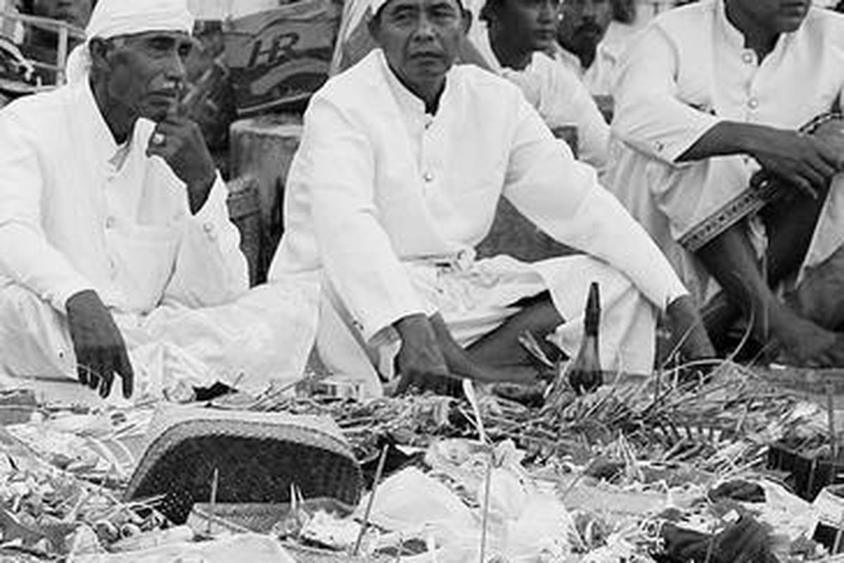 Warga duduk di depan berbagai sesaji menjelang pelaksanaan upacara penyucian diri Melasti di Pantai Nambo, Kendari, Sulawesi Tenggara, Selasa (20/3). Melasti dilakukan umat Hindu menjelang perayaan Nyepi Tahun Baru Saka 1934 yang jatuh pada Jumat, 23 Maret mendatang.