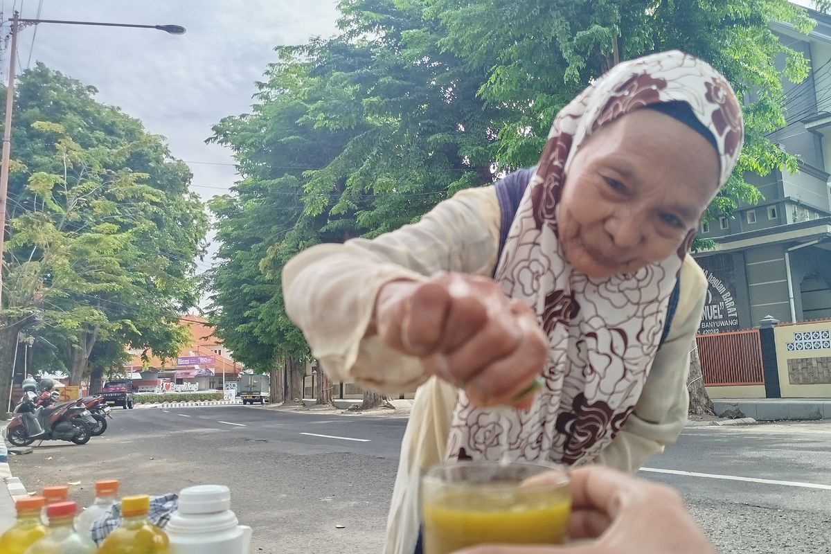 Parmi melayani pembeli jamu dengan cekatan di area Taman Blambangan Banyuwangi, Jumat, (10/1/2025). 