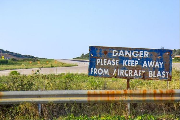 Papan peringatan semacam ini banyak dipasang di sekitar bandara internasional Skiathos, Yunani untuk mencegah para turis terlalu dekat dengan landasan pacu.