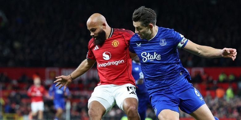 Bryan Mbeumo (kiri) dibayangi James Tarkowski (kanan) dalam pertandingan sepak bola Liga Inggris antara Manchester United vs Everton di Old Trafford di Manchester, barat laut Inggris, pada 24 November 2025. (Foto oleh Darren Staples / AFP) / DIBATASI UNTUK PENGGUNAAN EDITORIAL. Tidak ada penggunaan dengan audio, video, data, daftar perlengkapan, logo klub/liga, atau layanan 'langsung' yang tidak sah. Penggunaan dalam pertandingan online dibatasi hingga 120 gambar. 40 gambar tambahan dapat digunakan dalam waktu tambahan. Tidak ada emulasi video. Penggunaan media sosial yang cocok dibatasi hingga 120 gambar. 40 gambar tambahan dapat digunakan dalam waktu tambahan. Tidak digunakan dalam publikasi taruhan, permainan atau publikasi klub/liga/pemain tunggal. /
