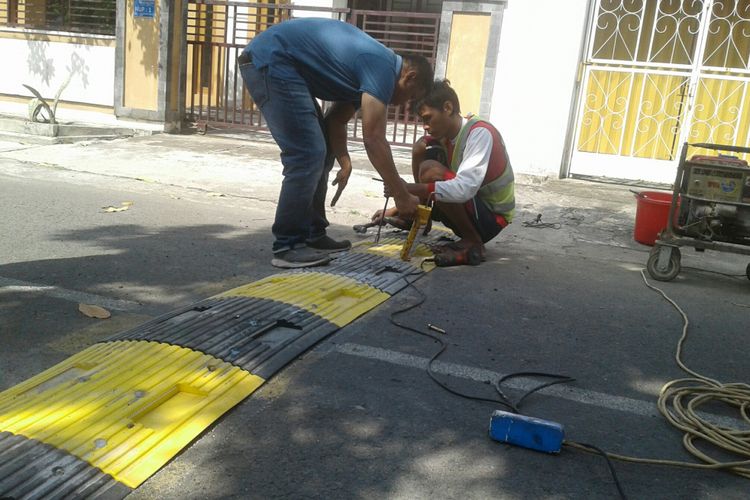 Petugas Dishub Kota Solo memasang alat pembatas kecepatan di Kampung Purwotomo, Purwosari, Laweyan, Solo, Jawa Tengah, Sabtu (26/5/2018).