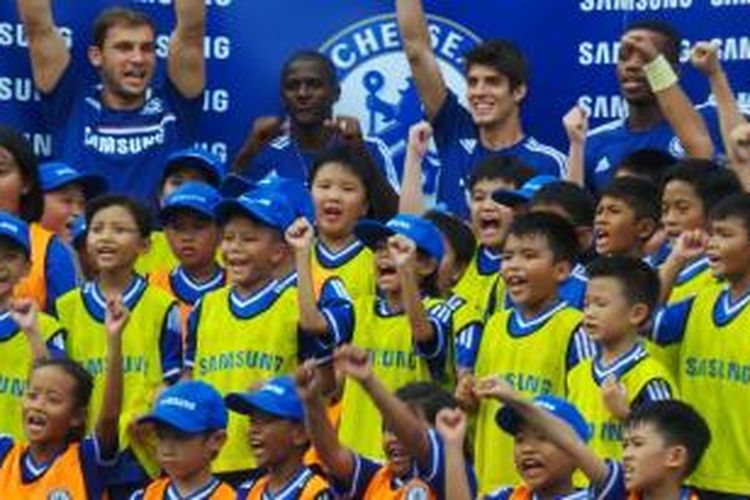 Empat pemain Chelsea, Branislav Ivanovic, Ramires, Lucas Paizon, dan Nathaniel Chalobah berfoto dengan anak-anak yang mengikuti klinik kepelatihan di Lapangan Hoki, Senayan, Rabu (24/7/2013). 