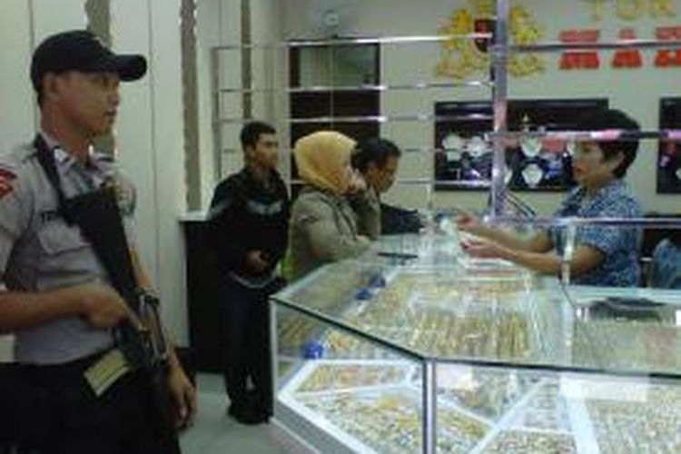 Petugas berjaga di salah satu toko emas di Solo, Selasa (30/7/2013).